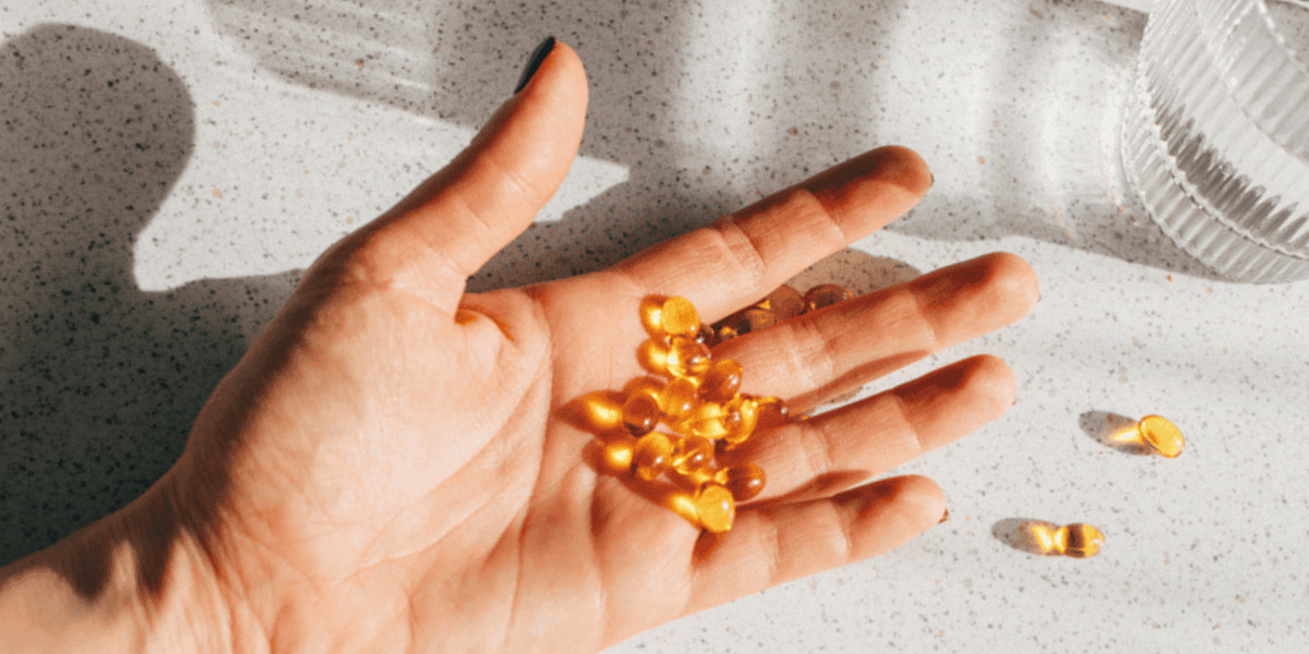 Afbeelding van foto van vitamine D capsules op een hand