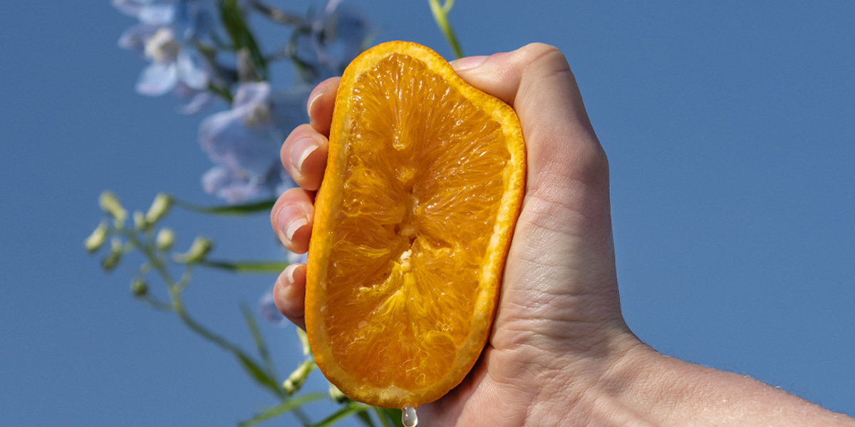 hand knijpt in sinaasappel