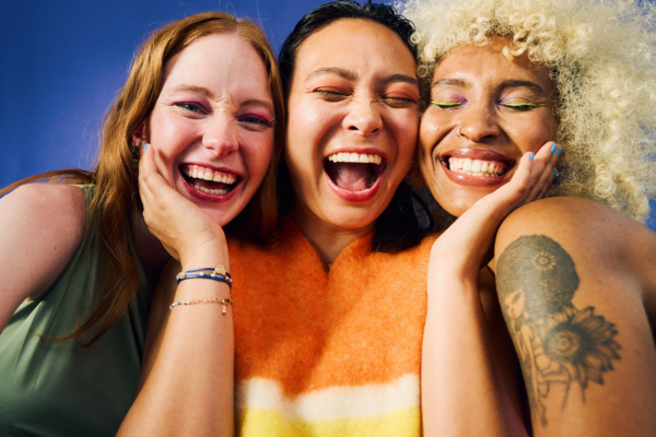 drie vrouwen bij elkaar lachen in de camera